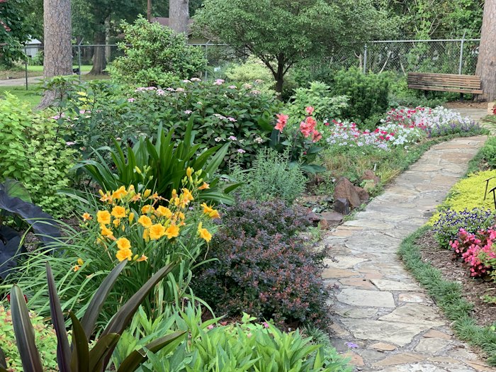 Allée en pierre dans un jardin fleuri